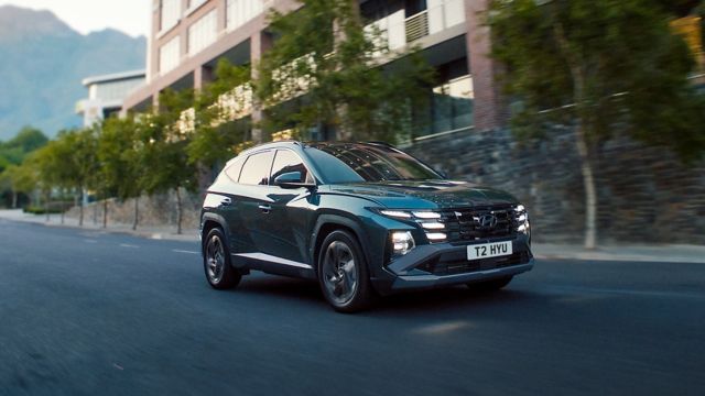 Hyundai TUCSON plug-in hybrid driving down a road.