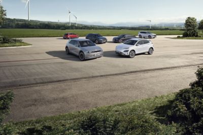 Hyundai range vehicles parked in front of a field.