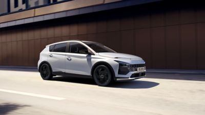 The Hyundai BAYON Black line driving along the road