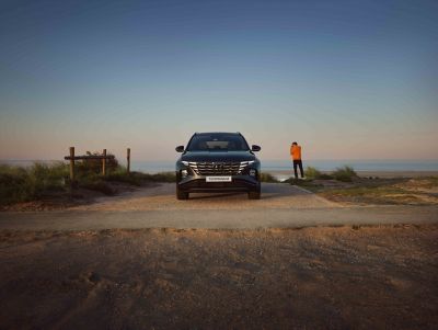 The Hyundai Tucson Hybrid compact SUV parked next to the sea.