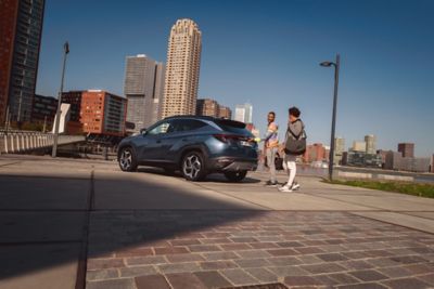 El SUV compacto Hyundai Tucson Hybrid aparcado en una calle de la ciudad, fotografiado de perfil.