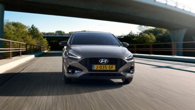 Hyundai i30 rijdend op een snelweg onder een viaduct.