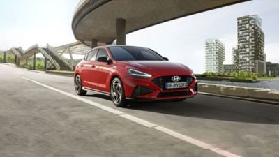 Nowy Hyundai i30 Fastback N Line zaparkowany na brukowanej ulicy