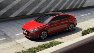 Predný trojštvrťový pohľad zhora na nový Hyundai i30 Fastback N Line červenej farby.
