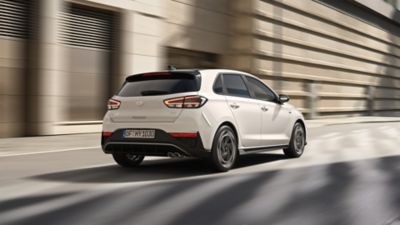 Ein Hyundai i30 Kombi N Line, schräg von hinten gesehen, fährt auf einer innerstädtischen Straße.