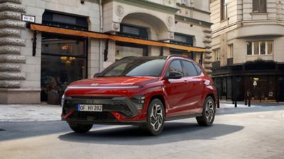 De All New Hyundai KONA N Line in het rood voor een gebouw van architectonische waarde. 