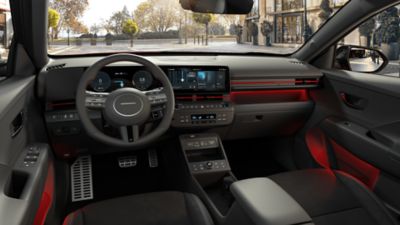 Dashboard and front door storage of the Hyundai KONA highlighted by a orange ambient mood lighting.