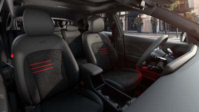 De voorzetels van de Hyundai KONA met rode N Line-accenten en rode sfeerverlichting.