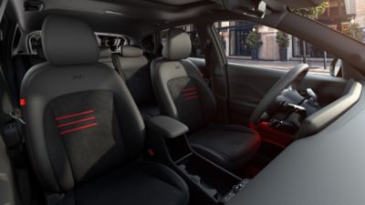 The sporty front seats of the Hyundai KONA N Line with red accents and ambient lighting.