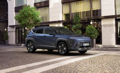 De All New Hyundai KONA geparkeerd naast een gebouw.