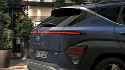 Le tout nouveau Hyundai KONA Hybride photographié de côté devant un bâtiment moderne. 