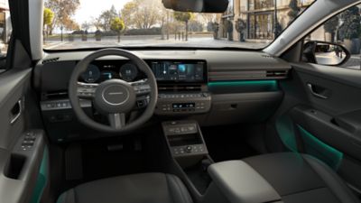 Blick in den vorderen Innenraum eines Hyundai KONA Elektro mit Armaturenbrett, Lenkrad und Bedienelementen.