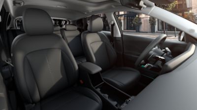 The inside view of the Hyundai KONA with green ambient lighting highlighting the display and the doors.