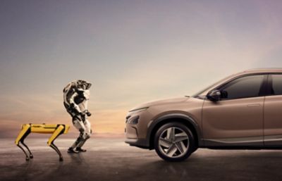 Robots Spot y Atlas de Boston Dynamics frente a un vehículo Hyundai NEXO de pila de combustible. 