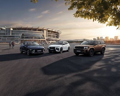 Hyundai KONA Electric, TUCSON Hybrid et IONIQ 9 stationnés près d’un stade de football