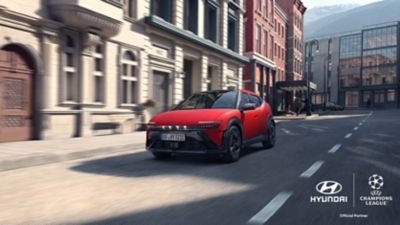 Red Hyundai IONIQ 3 shown from front three‑quarter angle on an urban street.