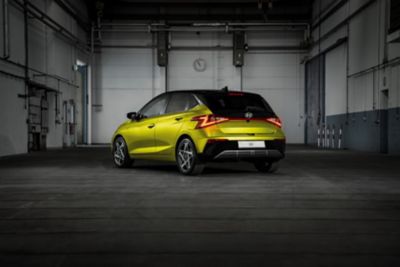 Il retro di Hyundai i20 gialla parcheggiata in un ambiente industriale chic.