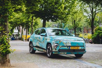 Hyundai KONA Electric gehuld in kleuren van schilderij ‘Amandelbloesem’ van Vincent van Gogh.