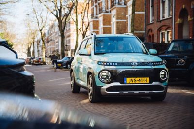 Hyundai INSTER gehuld in kleuren van schilderij ‘Amandelbloesem’ van Vincent van Gogh in straat in Amsterdam.