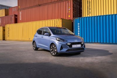 The new Hyundai i10 parked next to colourful shipping containers.
