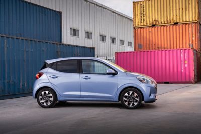 Nový Hyundai i10 z profilu vedle barevných přepravních kontejnerů.