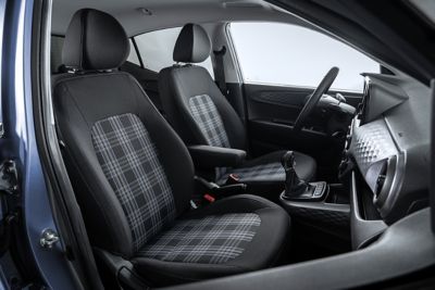 Les sièges avant de la nouvelle Hyundai i10 recouverts d'un tissu à motif écossais avec des lignes violettes verticales.