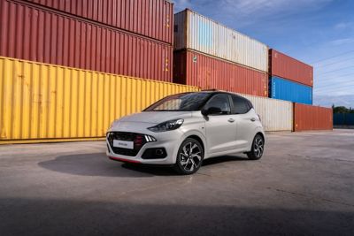 La nouvelle Hyundai i10 N Line garée à côté de conteneurs maritimes colorés.