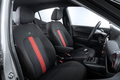 The front seats of the new Hyundai i10 N Line with red accents.