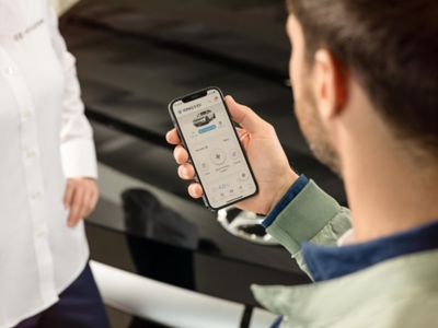 Un cliente Hyundai controlla la sua app MyHyundai sullo smartphone