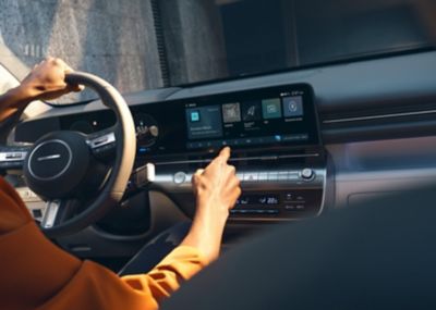 Un hombre utiliza la pantalla táctil central del Hyundai KONA.