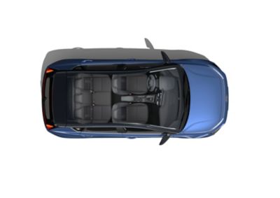 Blauwe Hyundai BAYON in vogelvlucht met een dakuitsnede die het ruime interieur toont.