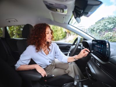  A woman using the 10.25" centre touchscreen of the Hyundai Bayon