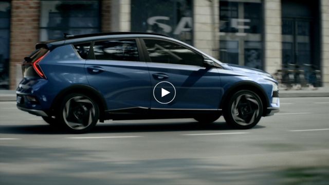 Hyundai BAYON driving through an urban street.