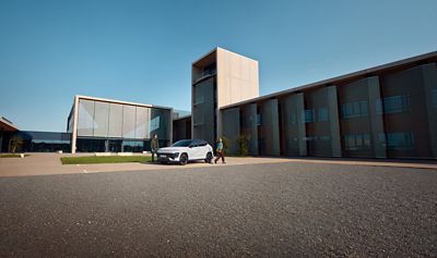 Hyundai KONA Electric ve slunečním světle s mužem, který odchází z garáže.