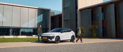 Driekwart vooraanzicht Hyundai KONA Electric met een man en een vrouw