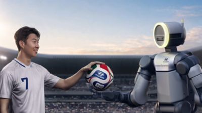 Hyundai ambassador Son Heung-min and Boston Dynamics humanoid robot, Atlas holding football.