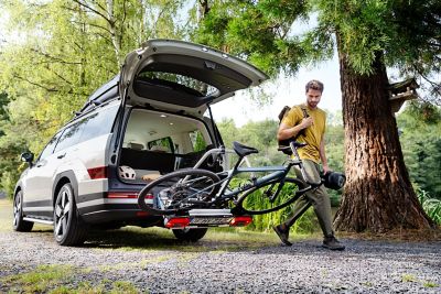 Hyundai SANTA FE z otwartą klapą bagażnika i rowerem na bagażniku rowerowym, montowanym do haka holowniczego.