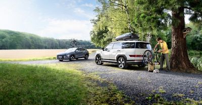 Hyundai with roof rack and bike rack drives in the mountains.