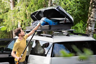 De dakkoffer 390 geplaatst op de dakdragers op het dak van de Hyundai SANTA FE.