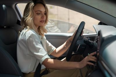 Looking inside a Hyundai through the windshield, a women in the car.