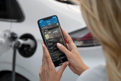 Picture of a woman checking the charging status of her Hyundai  Ioniq Hybrid on an app