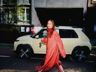 Une femme passe devant la nouvelle petite voiture électrique Hyundai INSTER.