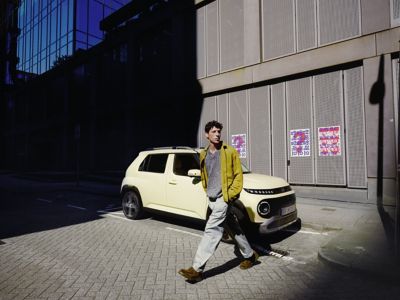 A man walking away from the new Hyundai INSTER small electric car.