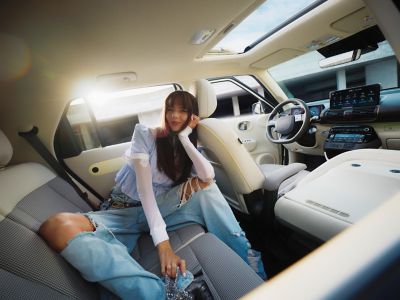 A woman sitting in the roomy back seat of the new Hyundai INSTER electric car.