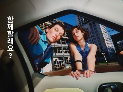 Une femme et un homme regardent l'intérieur de la nouvelle petite voiture électrique Hyundai INSTER.