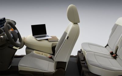 A side view of the folded passenger seat with a laptop on in inside of the new Hyundai INSTER.