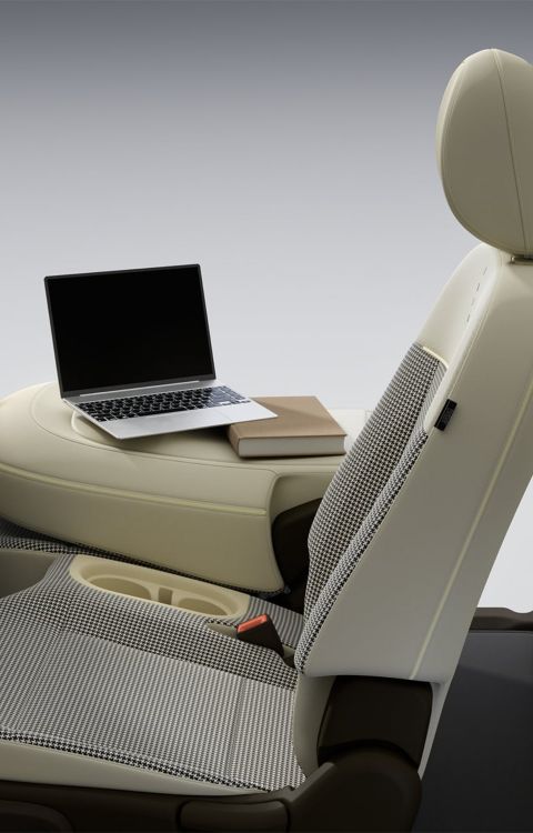 A side view of the folded passenger seat with a laptop on in inside of the new Hyundai INSTER.