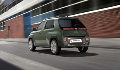 The Hyundai INSTER Cross driving on a city street.