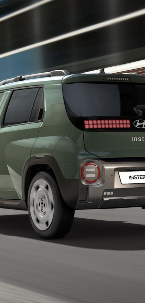 The Hyundai INSTER Cross driving on a city street.