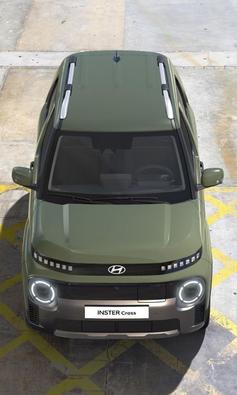 The rear view of Hyundai INSTER Cross trim parked on the hill.